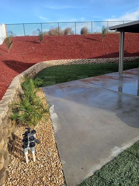 Completed irrigation project – green lawn with active sprinklers running